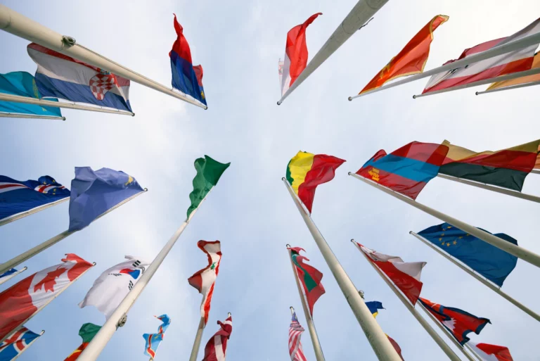 A group of flags on flagpoles representing various countries